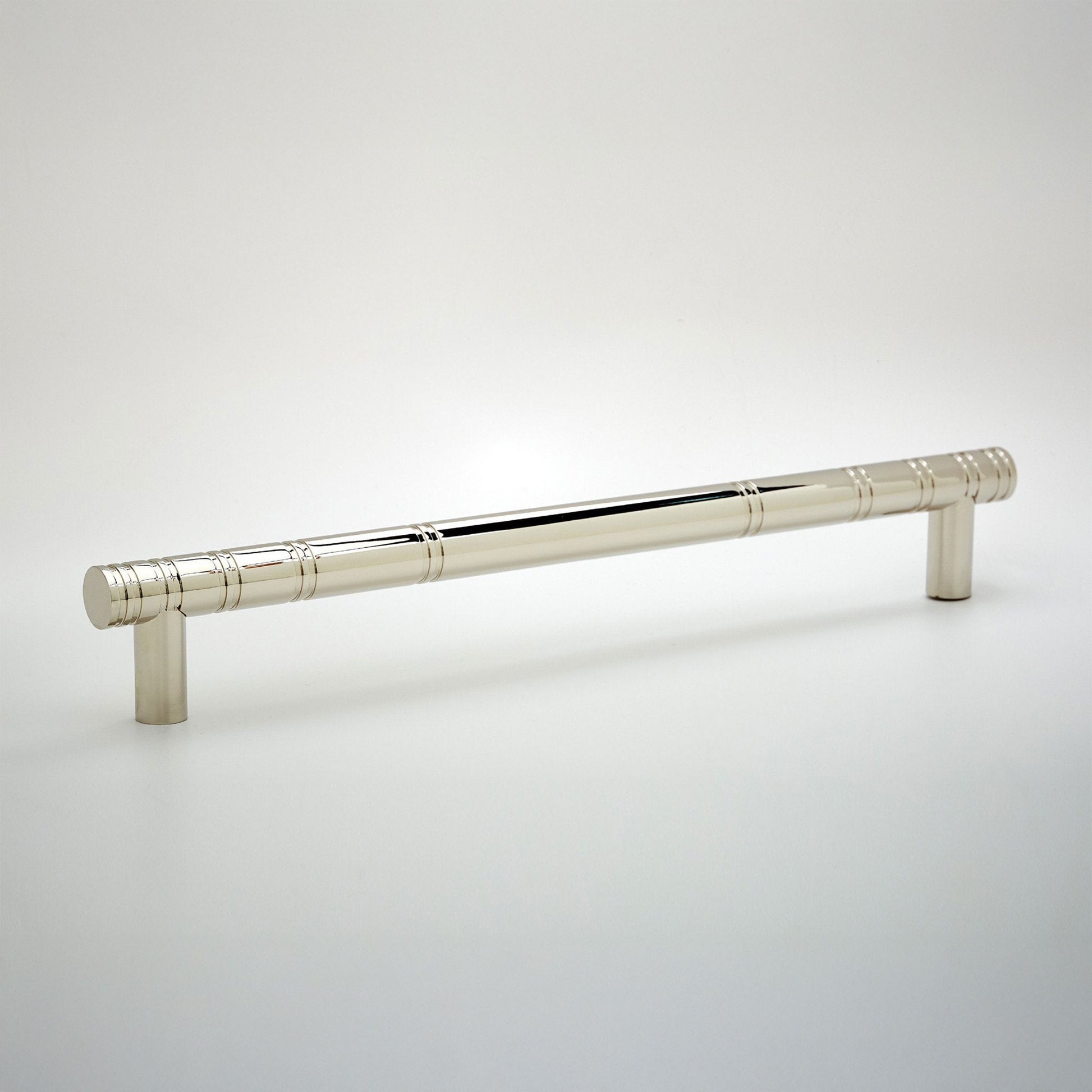 A polished silver cabinet pull handle with a cylindrical rod and two cylindrical posts, shown on a light gray gradient background.