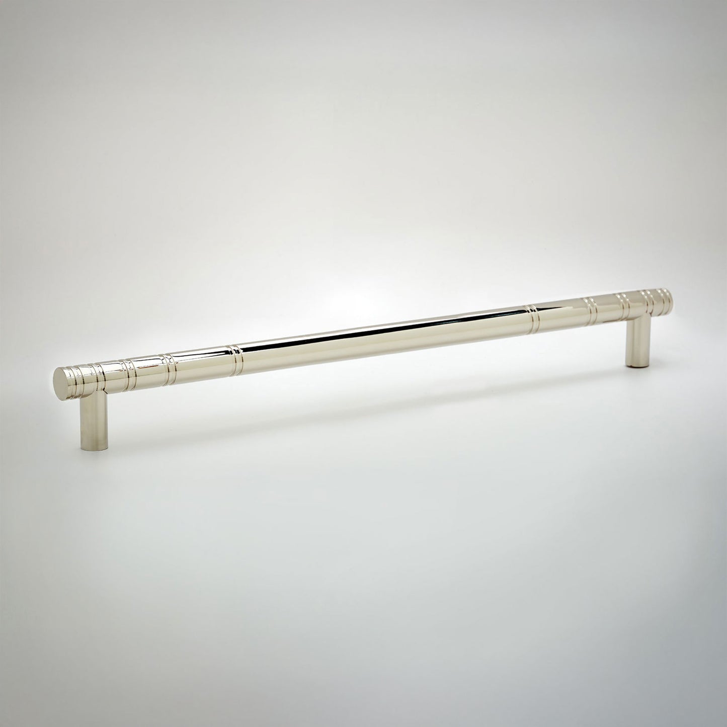 A polished silver cabinet pull handle with a cylindrical rod and decorative knurled ends, shown on a light gray gradient background.