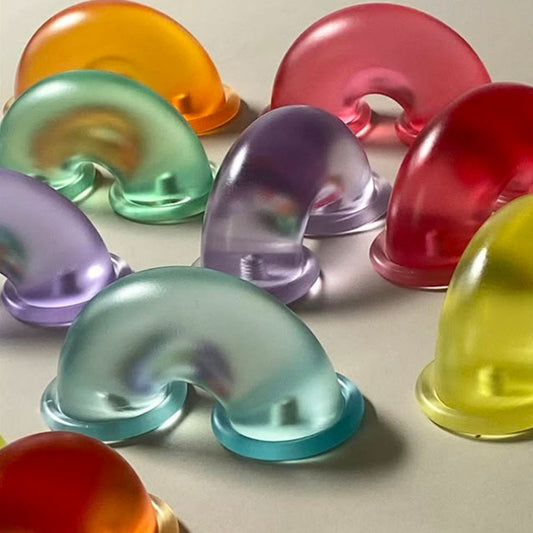 A grouping of colorfull translucent macaroni shaped cabinet pulls on a greige background