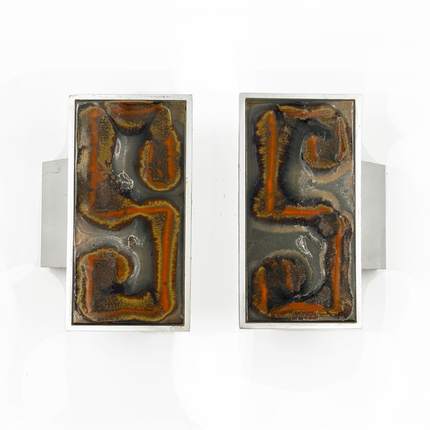 A pair of rectangular silver-toned door handles with abstract Orange, russet and tan textured inlay on a dark background, shown against a plain white background.