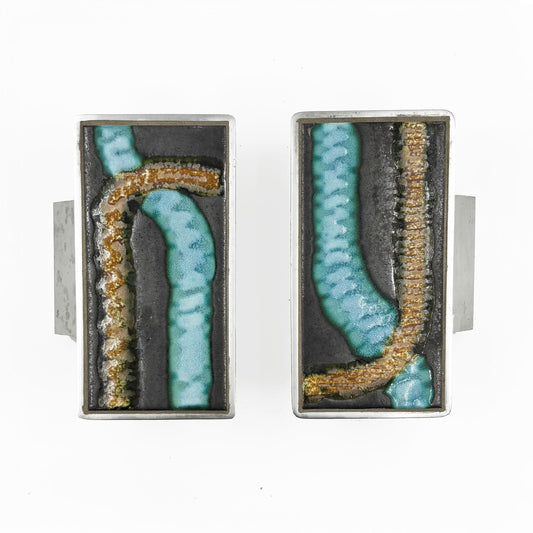 A pair of rectangular silver-toned door handles with abstract turquoise and gold textured inlay on a dark background, shown against a plain white background.