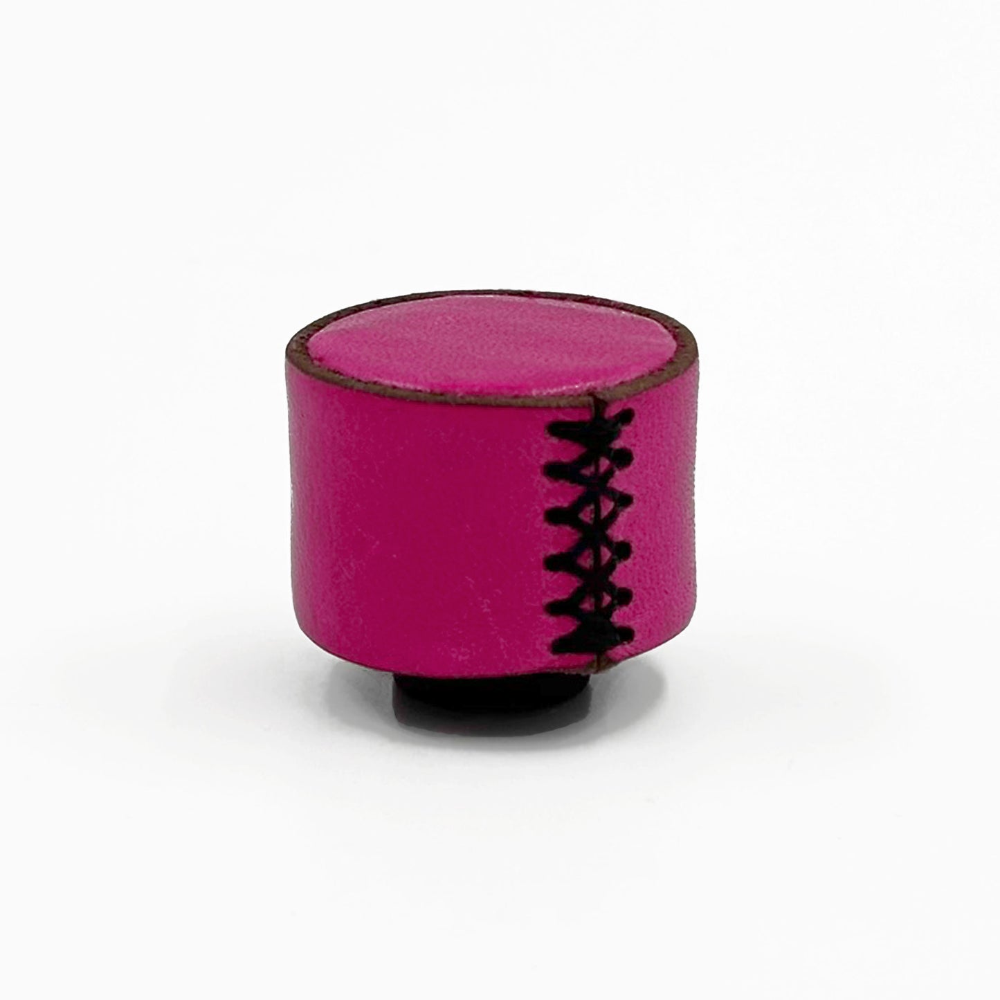 A small cylindrical magenta pink cabinet knob with leather stitching and black laces, shown on a plain white background.