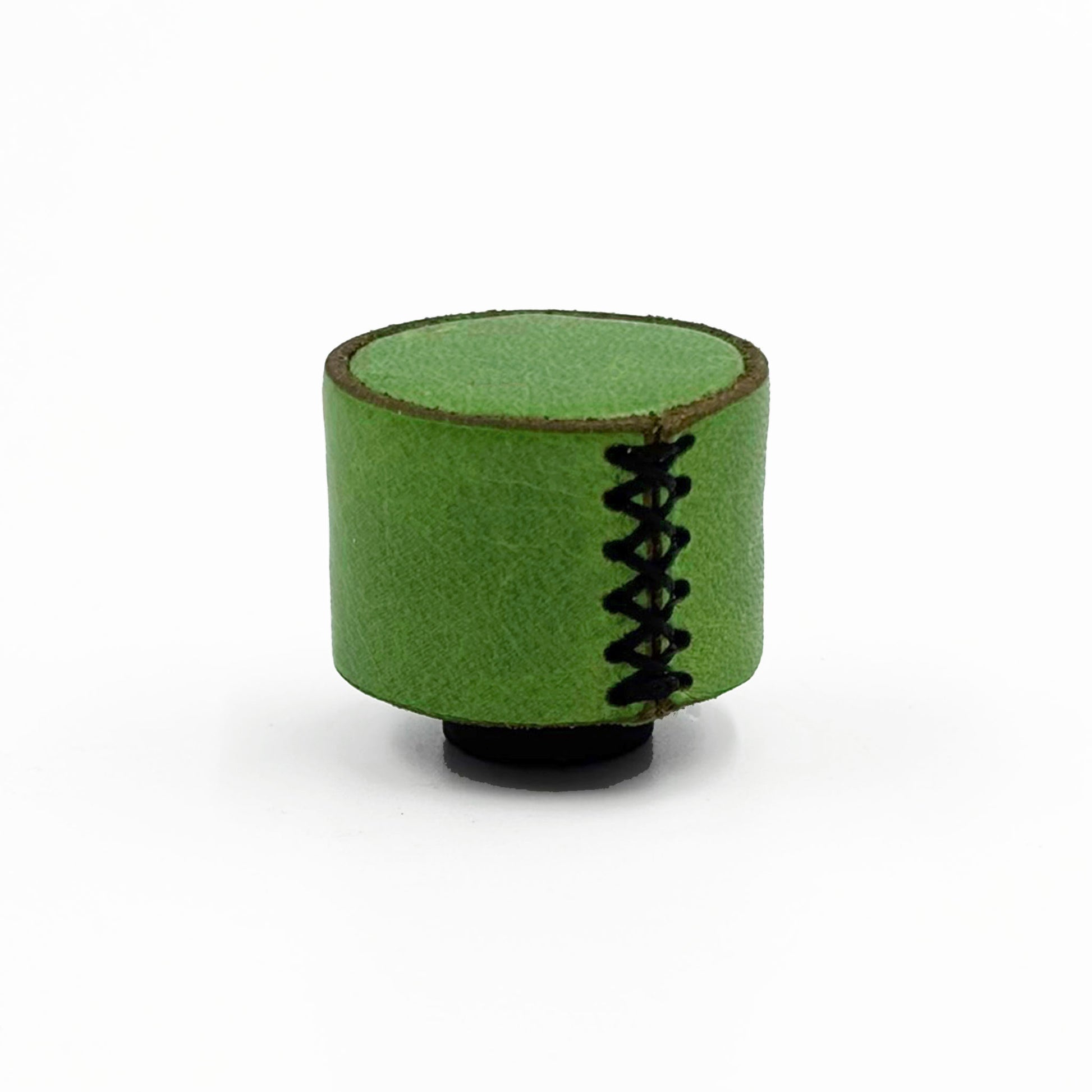 A small cylindrical green cabinet knob with leather texture, black decorative stitching down the front, and a black base, photographed on a plain white background.