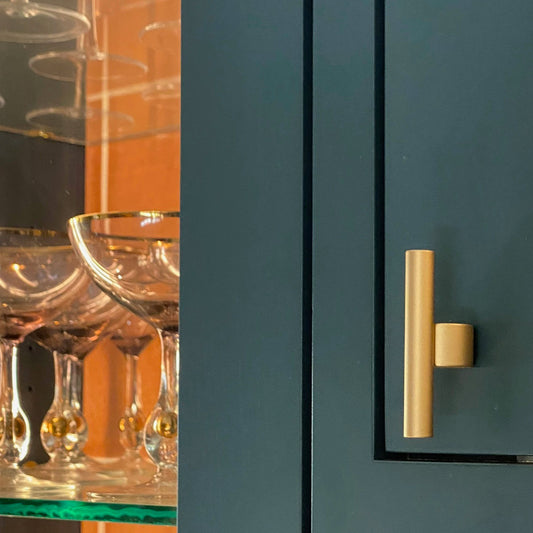 a counterbalace T-Pull in Satin Brass installed in a colorful kitchen door