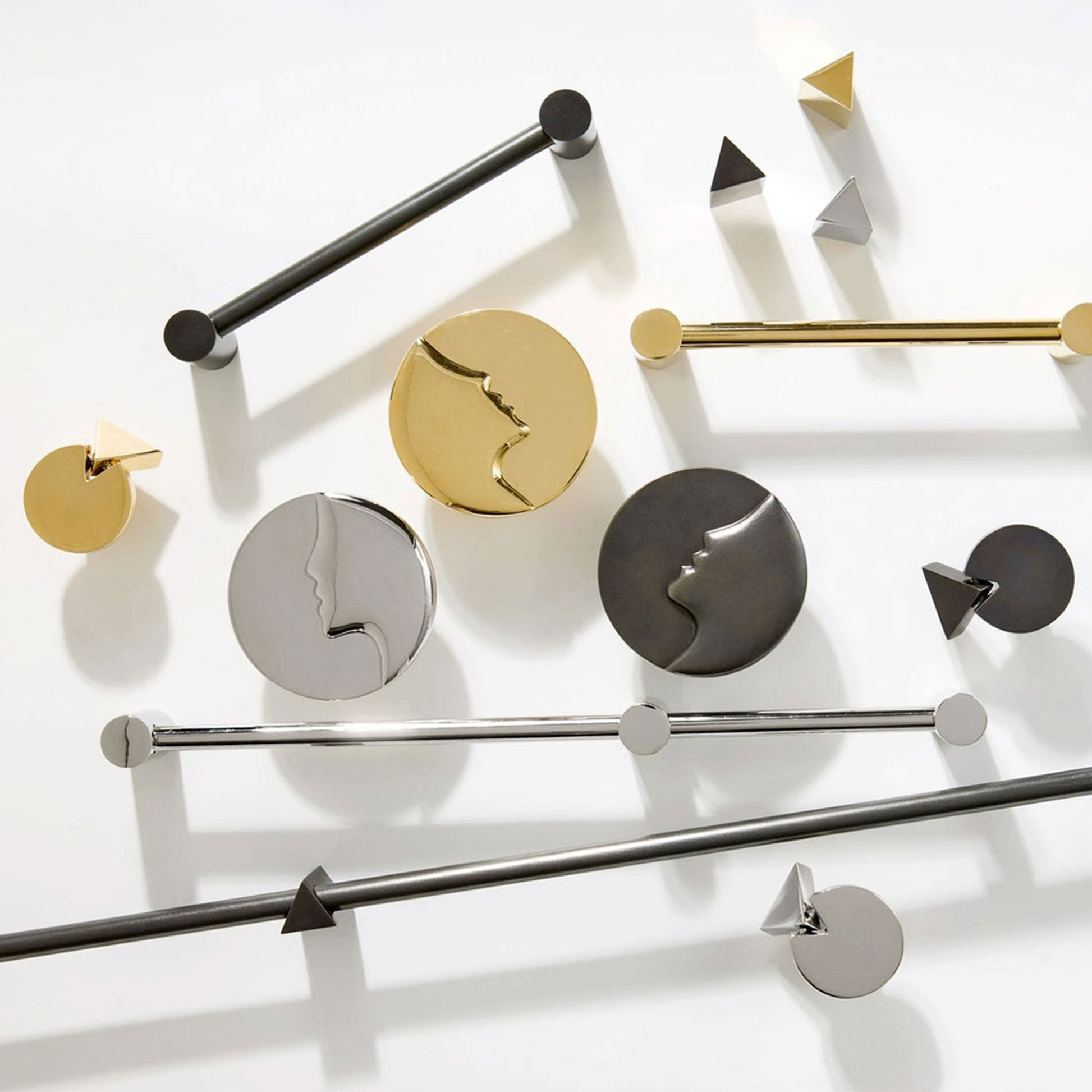 A collection of modern metal cabinet knob and handles in polished gold, matte black, and brushed silver, arranged on a clean white background.