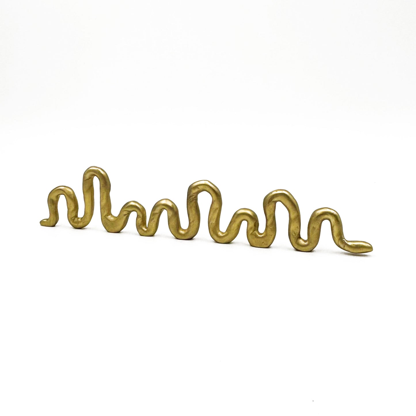 A squiggly snake shaped matte brass colored cabinet pull in a white background