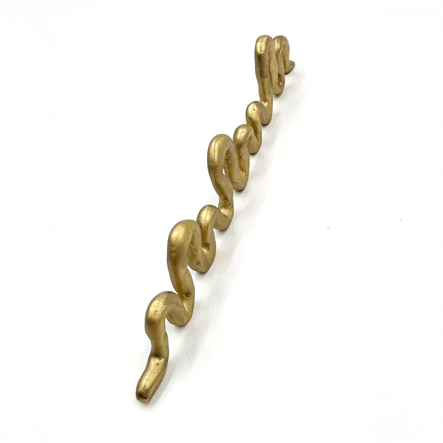 A squiggly snake shaped matte brass colored cabinet pull shown from the top on a white background