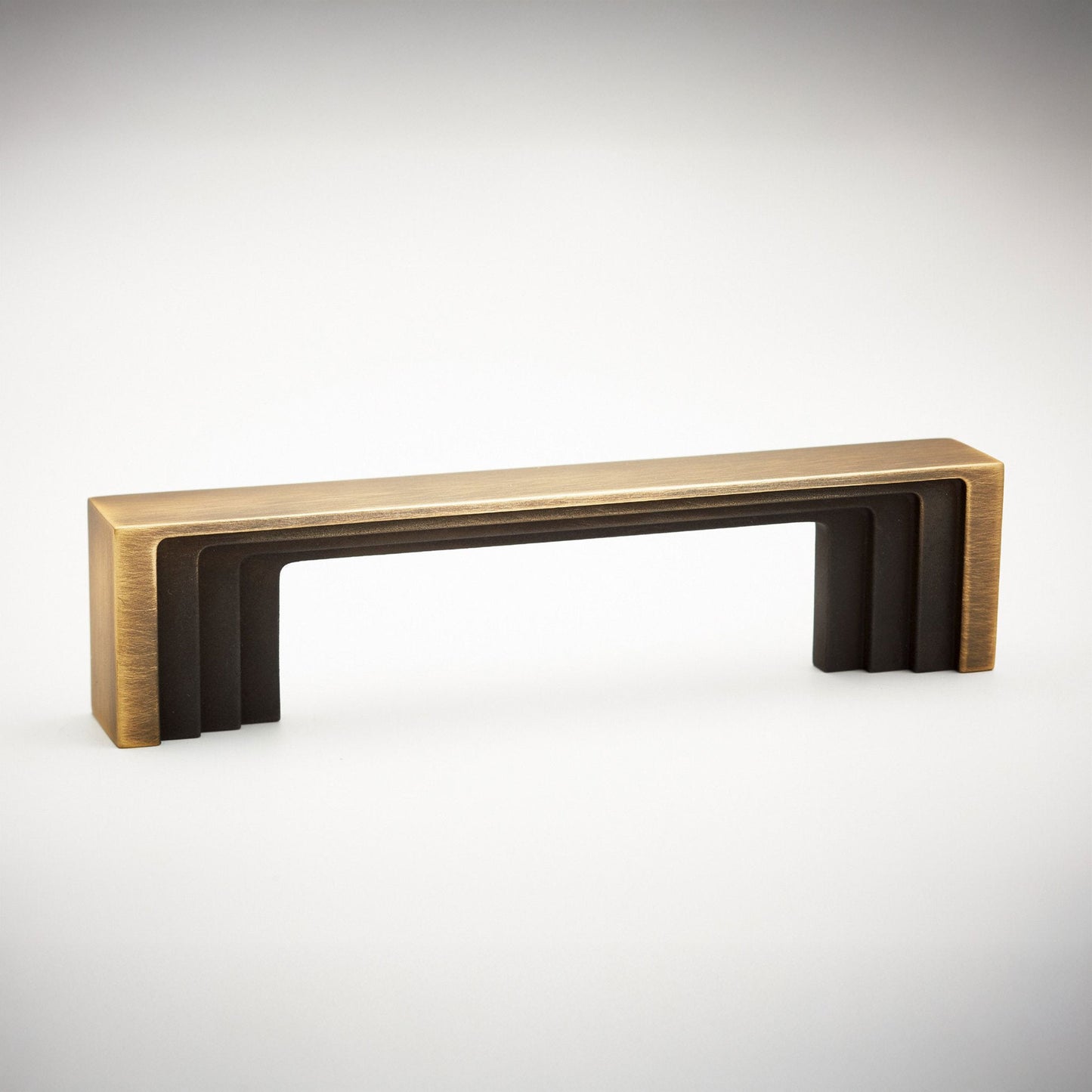 A modern rectangular cabinet pull handle with a brushed gold outer frame and dark bronze inner slats, shown on a clean white background.