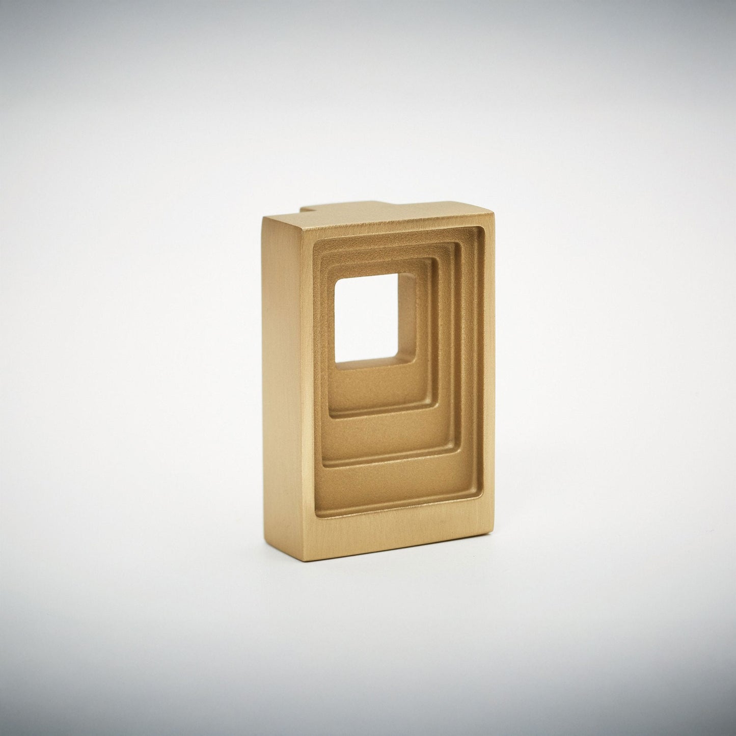 A square metallic gold hardware cabinet Pull with a recessed square cutout, shown on a light gray gradient background.