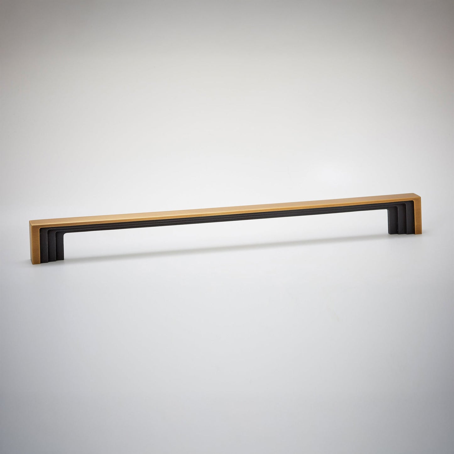 A modern long cabinet pull handle featuring a light natural wood top and a black geometric frame, shown against a neutral light gray background.