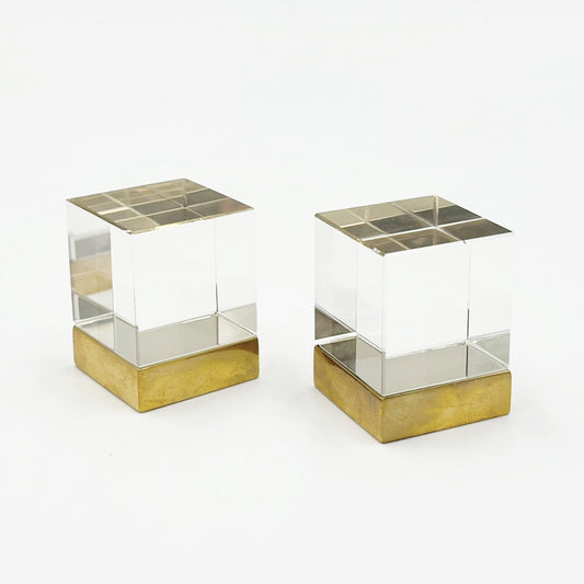 Two Glass cube shaped cainet knobs with unlacquered brass bases on a white background