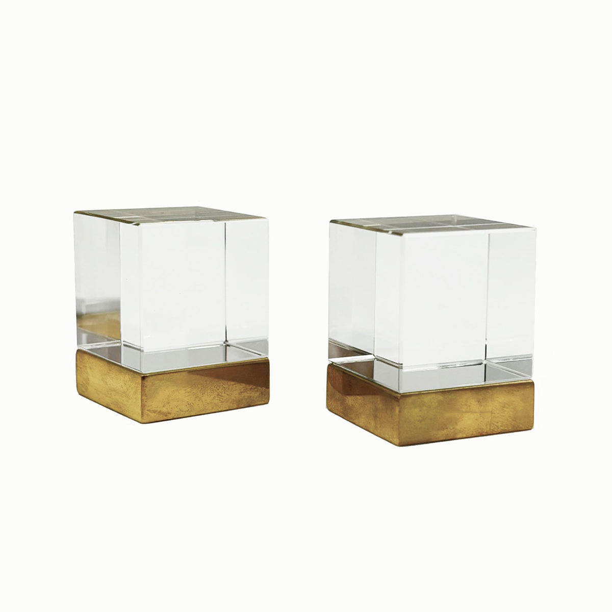 Two Glass cube shaped cainet knobs with unlacquered brass bases on a white background