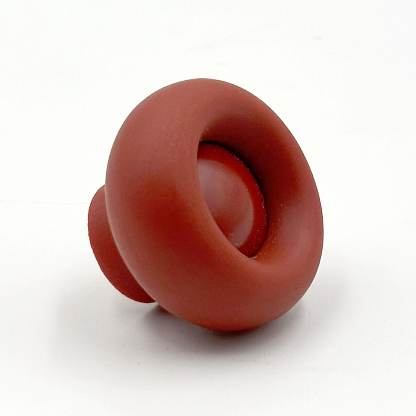 Chunky red colored cabinet knob on it's side on a white background