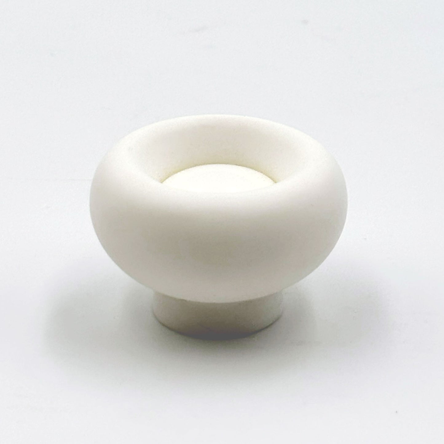 Chunky white colored cabinet knobs on a white background