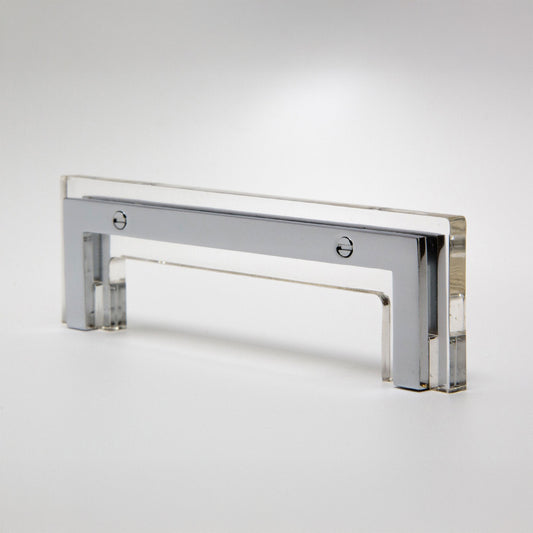 A modern rectangular acrylic cabinet pull handle with a polished chrome frame, shown on a clean white studio background.