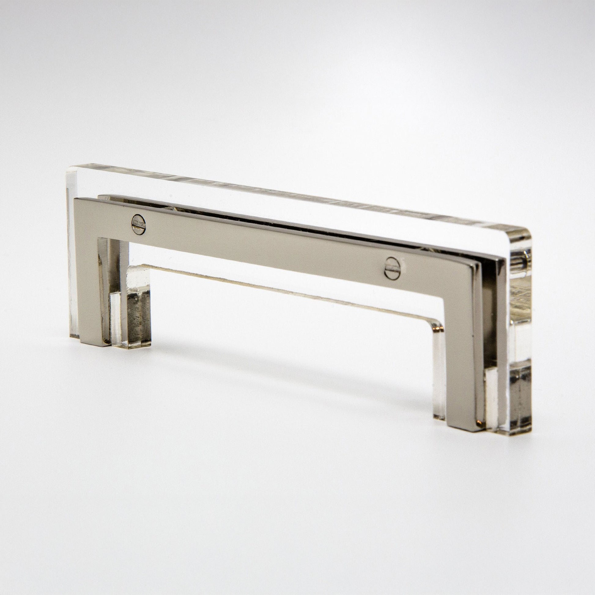 A modern rectangular cabinet pull handle made of polished silver-toned metal with a clear acrylic or glass front panel, shown on a clean white studio background.