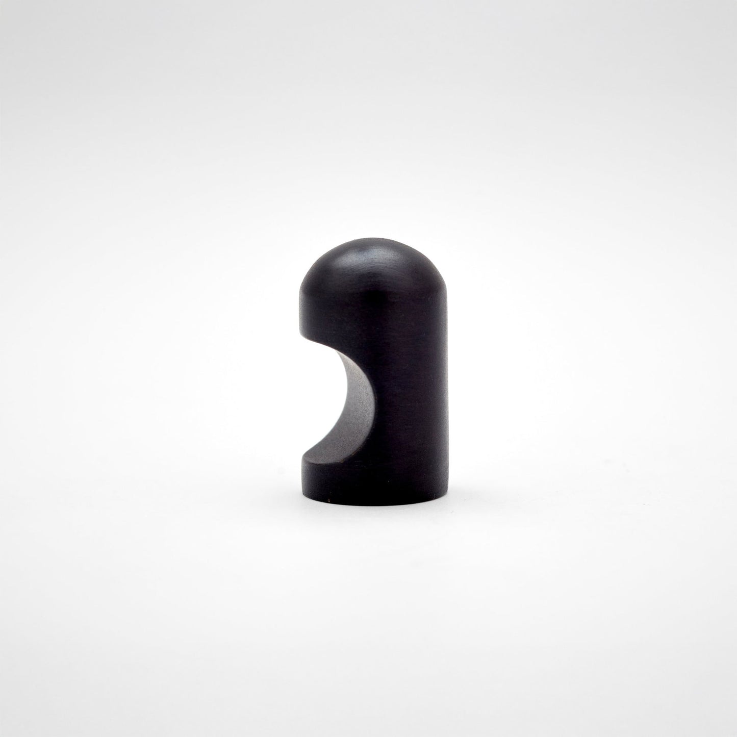 A small metallic cabinet knob with a rounded top and a curved cutout on the side, photographed on a clean light gray studio background.