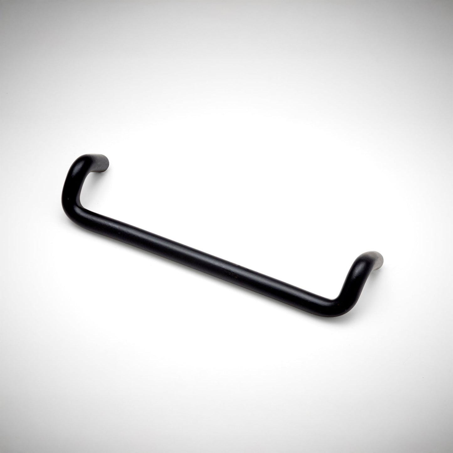 A matte black metal cabinet pull with a curved, U-shaped design, shown on a clean white background with a subtle vignette.