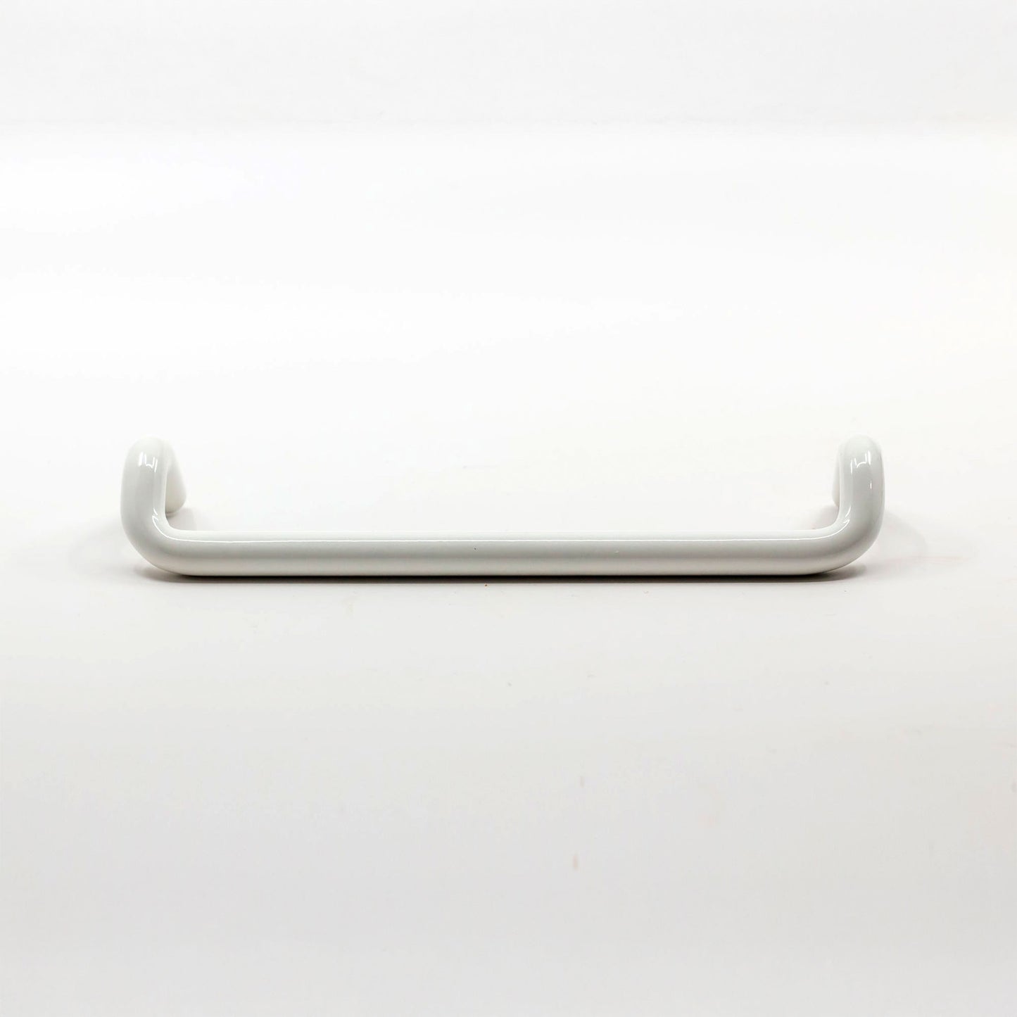 A white cabinet pull with a curved, rounded design, shown horizontally against a seamless white background.