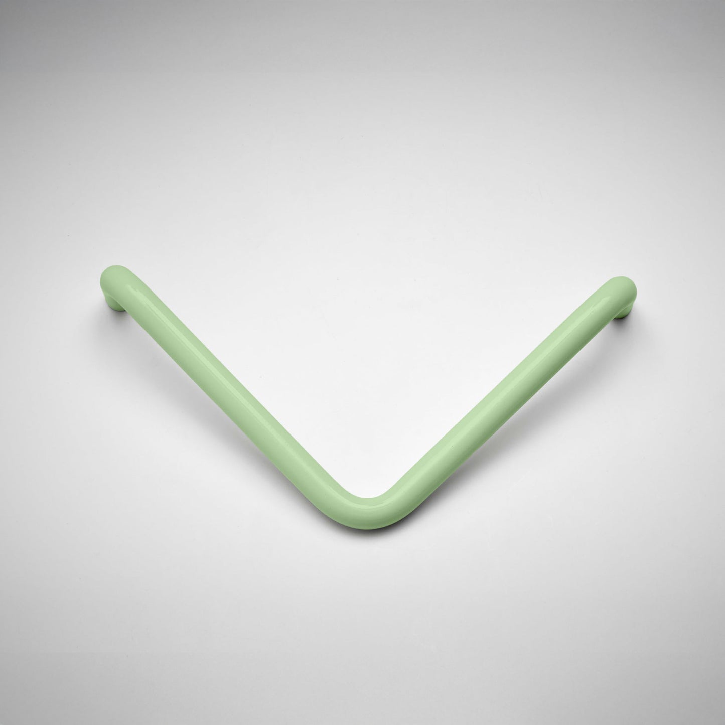 A minimalist V-shaped metal cabinet pull handle in a matte sage green finish, shown on a clean light gray gradient background.