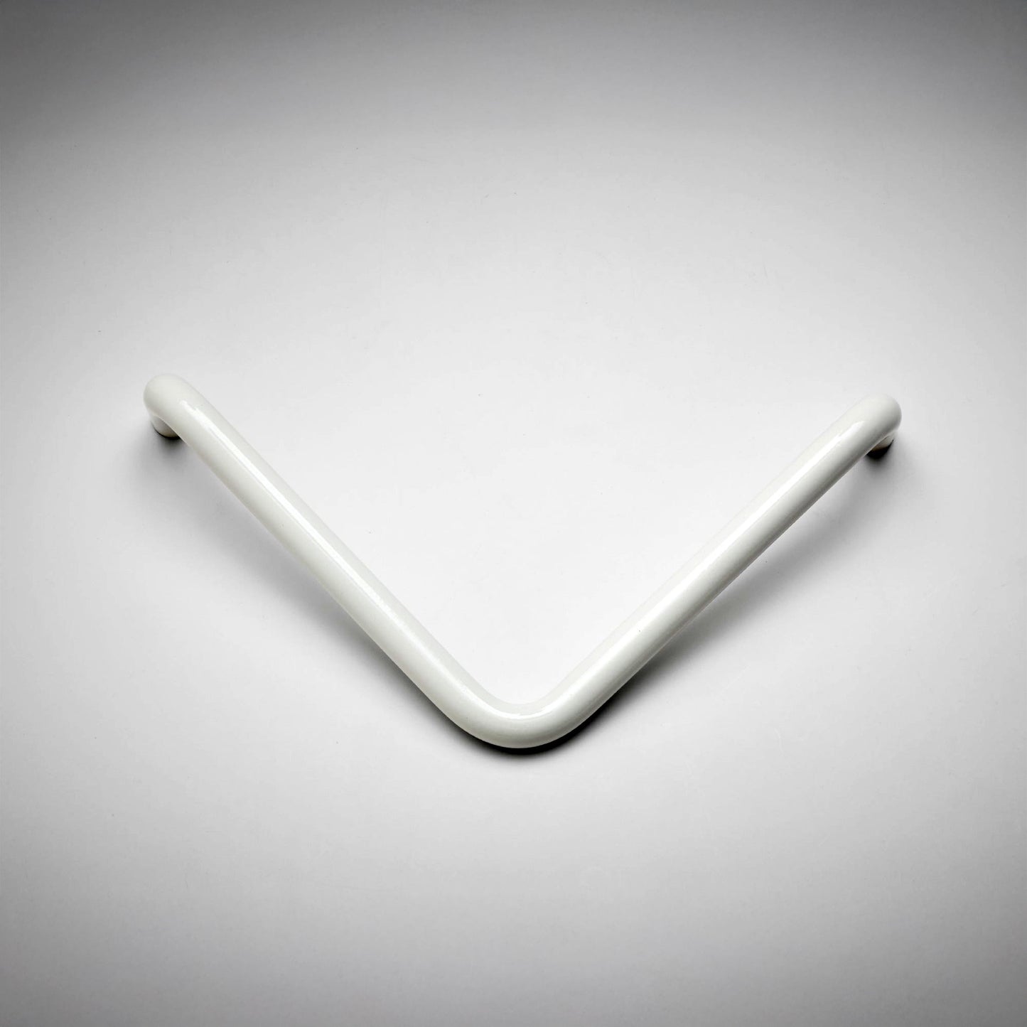 A modern, minimalist V-shaped cabinet pull handle in a glossy white finish, photographed on a clean, light gray gradient background.
