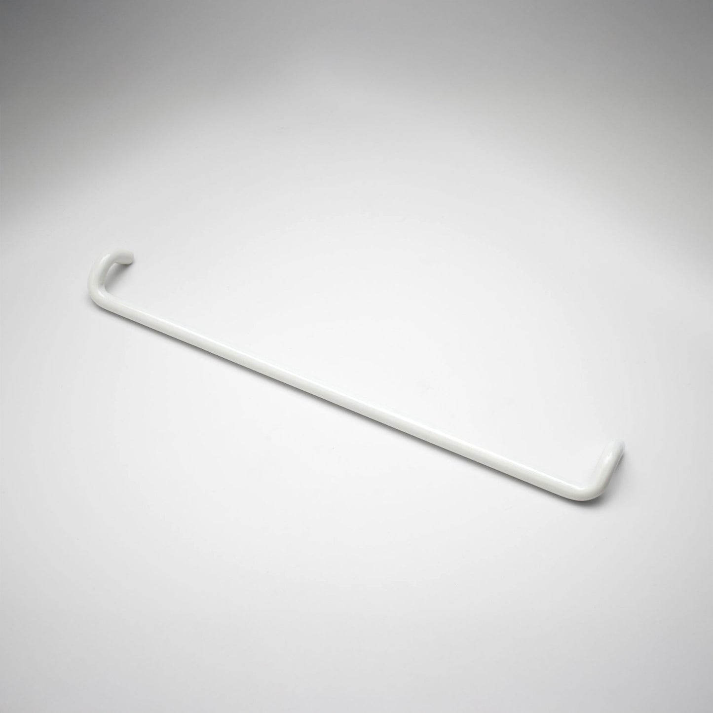 A minimalist white metal cabinet pull with a curved, modern design, shown on a clean light gray background.