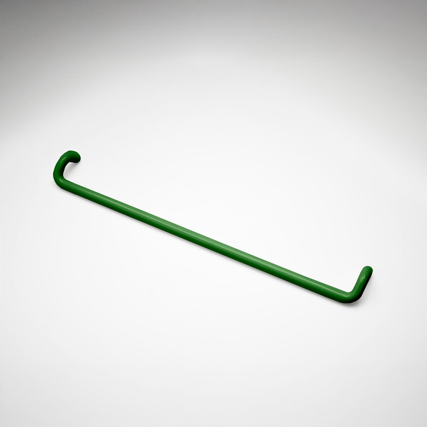 A minimalist green metal cabinet pull with a curved, modern design, shown on a clean light gray background.