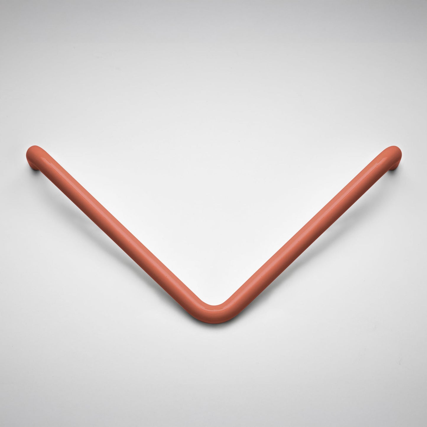 A modern V-shaped cabinet pull in a matte terracotta finish, photographed on a clean light gray background.