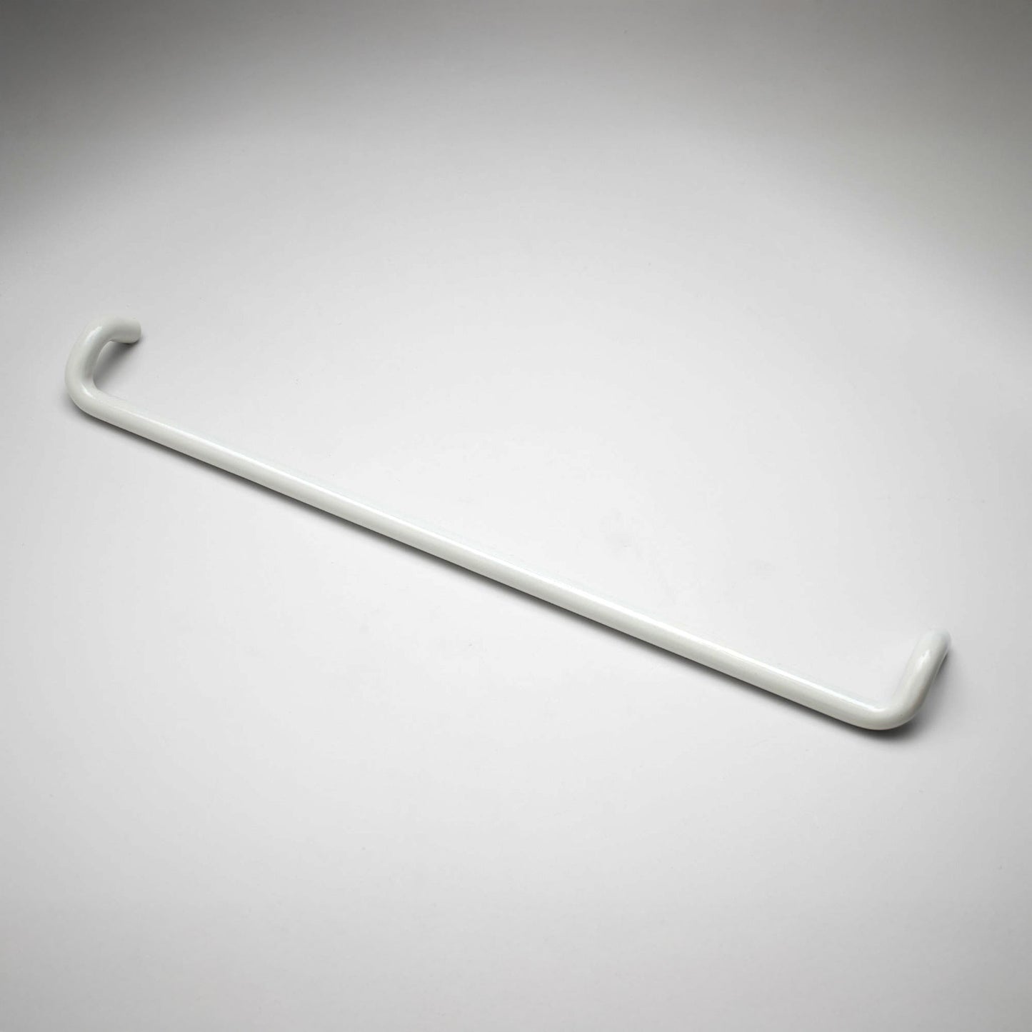 A minimalist white metal cabinet pull with a curved, modern design, shown on a clean light gray background.