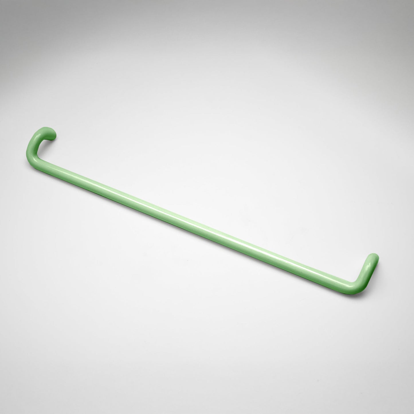 A minimalist mint metal cabinet pull with a curved, modern design, shown on a clean light gray background.