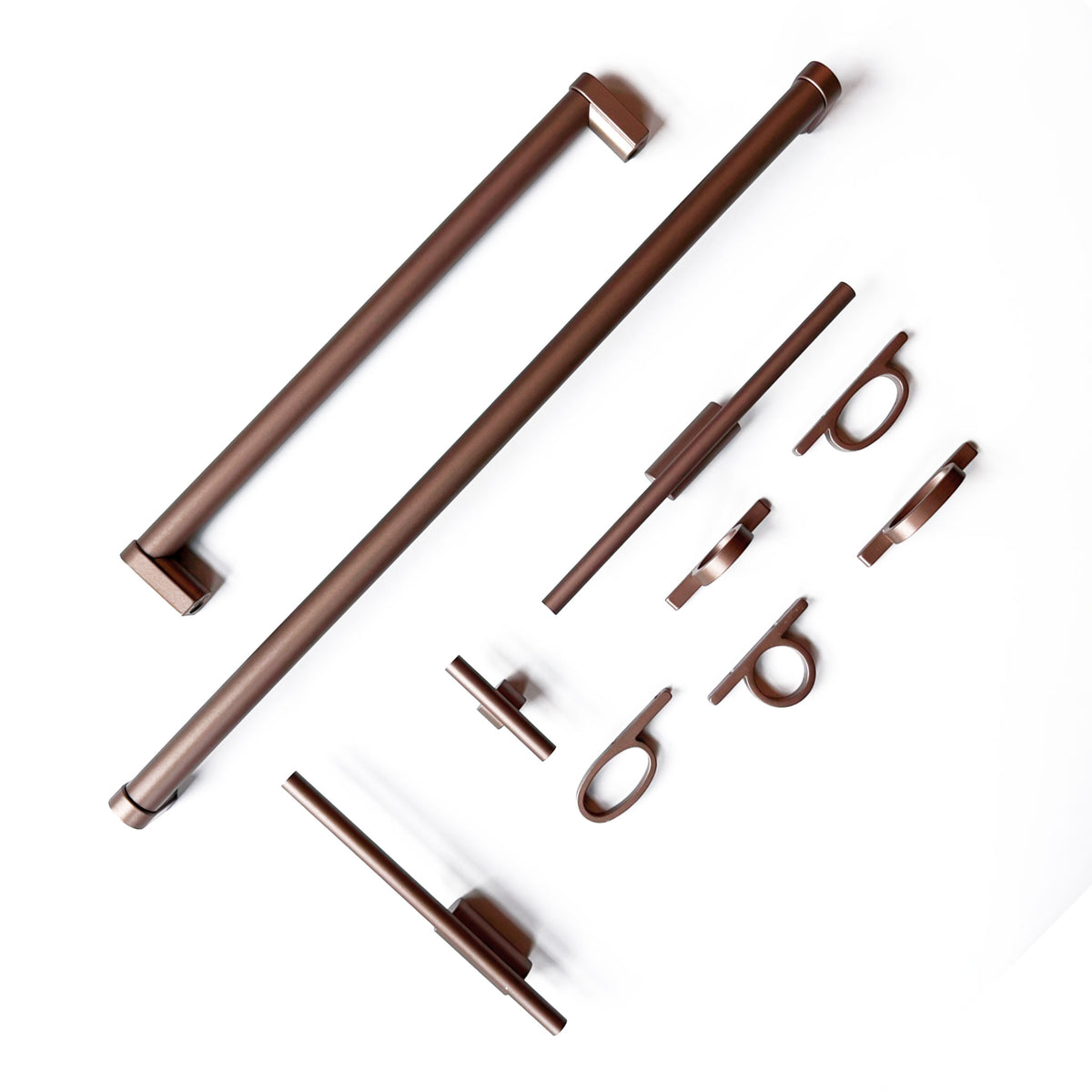a grouping of various cabinet and appliance pulls in a copper bronze finish  on a solid white background