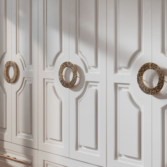 Brass Half Circle shaped cabinet pulls on a white cabinet doors